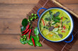 Thai chicken green curry on wooden background. top view