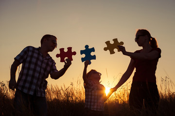 Wall Mural - Happy family playing at the park at the sunset time.