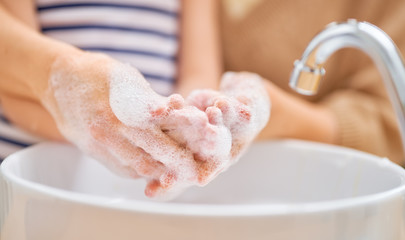 Kid and adult are washing their hands