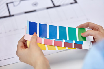 Sticker - interior design, architecture and people concept - close up of designer's hands with color palettes and blueprint