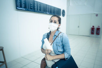 Wall Mural - Coronavirus outbreak travel restrictions. Traveler with mask at airport affected by travel ban and flight cancellations and Borders shutdowns.