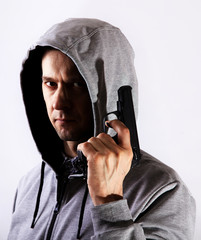 Wall Mural - Fearful man holds gun and hood on head in hand, major plan