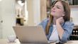 © stockbakers - Creative Woman with Neck Pain Busy Working on Laptop