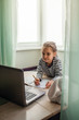 © Maria - Pretty stylish schoolgirl studying math during her online lesson at home, self-isolation