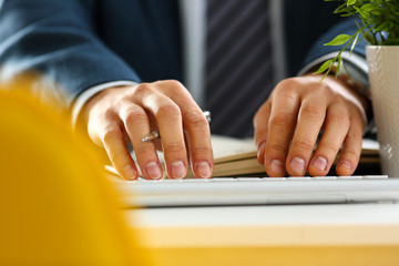 Male arms in suit typing on silver keyboard using computer pc at office workplace closeup. Accountant finger job modern lifestyle web search assistant enter account login password and note credential