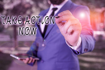 Text sign showing Take Action Now. Business photo text do something official or concerted achieve aim with problem Businessman holds laptop and pen pointing into the copy space