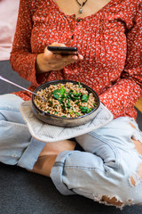 Wall Mural - Make photo of buckwheat grain porridge with phone in woman hands. Smartphone food photography picture. Vegan, vegetarian healthy diet.