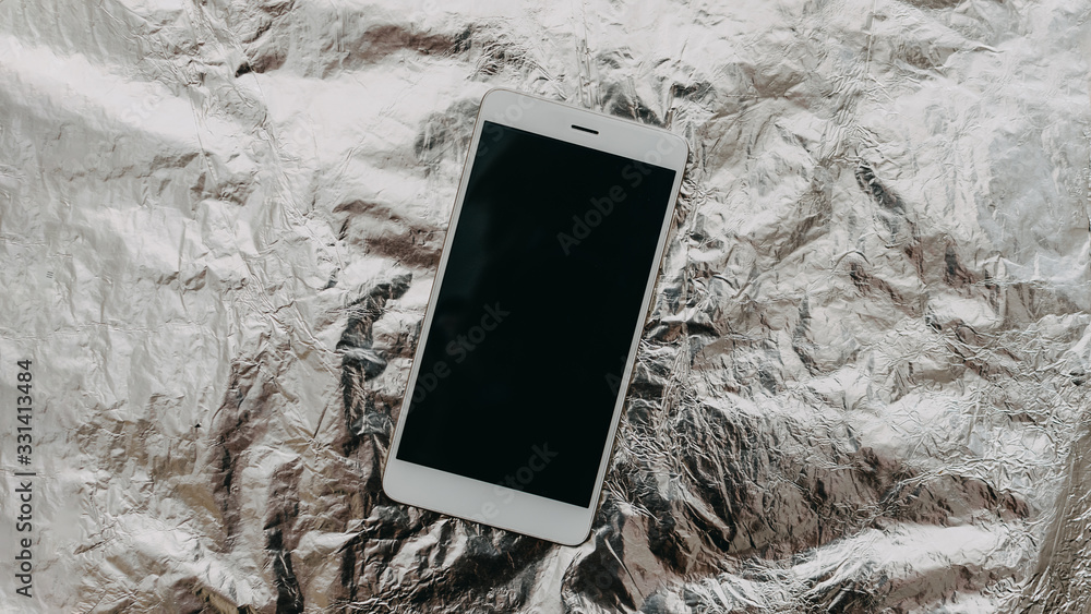 Cell Phone Radiation protect, Mobile Phone Anti-Radiation, Powering Down, Radiation-blocking materials, digital emissions protect concept. Mobile Phone on foil background