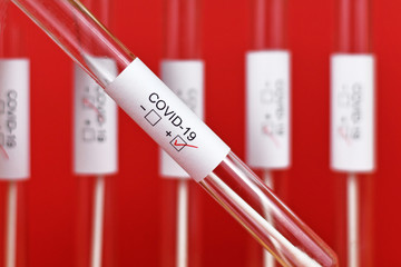 Wall Mural - positive medical test tube sample for coronavirus with label covid-19 with other blury tubes in red 