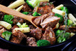 Spicy pork kebabs with vegetables on a black dish