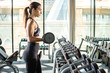 © Bojan - Fitness woman lifting dumbbell while standing in front of the mirror at gym