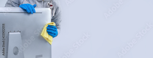 Fotografía Young woman housekeeper in apron is cleaning silver computer surface with blue gloves, wet yellow rag, close up, copy space, blank design concept