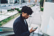 © BullRun - African American man using smartphone on escalator