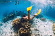 © artifirsov - Woman freediver swimming over with yellow fins in ocean. Freediving or snorkeling in Mauritius