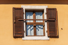 Close-up Of A Window With Open Brown Wooden Shutters With Spike Steel Sticks To Prevent Birds From Stopping, Especially Pigeons, Residential Building In Trentino, Italy, Europe