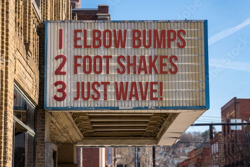 Movie cinema billboard with three rules to replace handshakes with elbow bumps, footshakes or just waving to friend during coronavirus epidemic