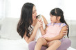 © Seksan - Asian mother playing with her daughter on the bed. The daughter is happy and laughing. Motherhood, mom and kids, healthy of children concept.