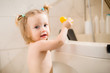 © КРИСТИНА Игумнова - Toddler girl bathes in bath with foam at home, plays with rubber duck