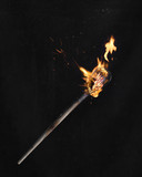 Fototapeta  - wooden burning torch on a black background
