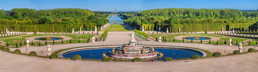 Panoramic view of the Versailles Park - the Latona Basin with the Grand Canal in the background under the summer sun, Versailles, France