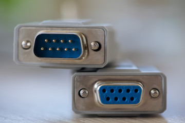 Close-up of a RS-232 serial port. Female to male extension cord on a wooden table.