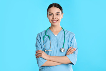 Poster - Portrait of young doctor with stethoscope on blue background