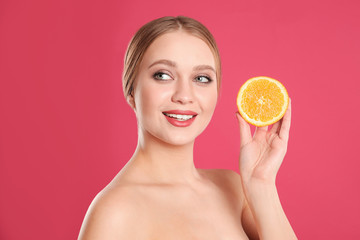 Sticker - Young woman with cut orange on pink background. Vitamin rich food