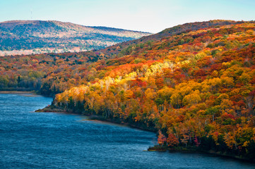 Wall Mural - Shafts of sunlight play across the fall colors on the shore of Lake of the Clouds in the Porcupine Mountains Wilderness State Park, Michigan.