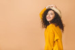 © denis_vermenko - Portrait of a cheerful beautiful curly smiling girl in straw hat isolated over beige background.