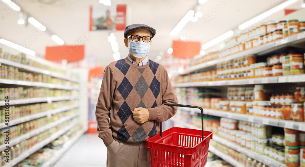 Senior man shopping in a supermarket with a medical face mask on - obrazy, fototapety, plakaty 