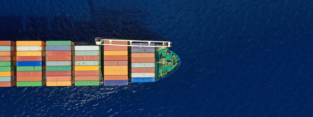 Aerial drone top down photo of fully loaded large truck size container tanker ship cruising the Mediterranean deep blue sea