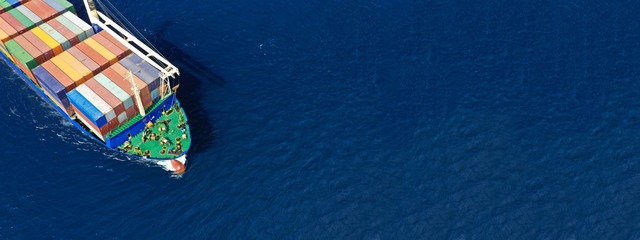 Aerial drone top down photo of fully loaded large truck size container tanker ship cruising the Mediterranean deep blue sea