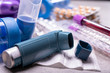 © barmalini - Different medicaments for asthma threatment, pills, inhalers, blood test-tubes and syringe, hospital background