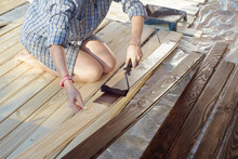 Home Improvement - Handywoman Painting Wooden Plank Outdoors