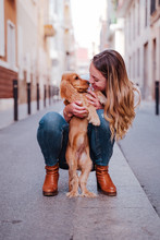 Young Woman At The Street Hugging Her Cute Cocker Dog. Lifestyle Outdoors With Pets