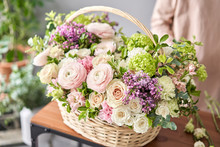 Floral Shop Concept . Florist Woman Creates Flower Arrangement In A Wicker Basket. Beautiful Bouquet Of Mixed Flowers. Handsome Fresh Bunch. Flowers Delivery.