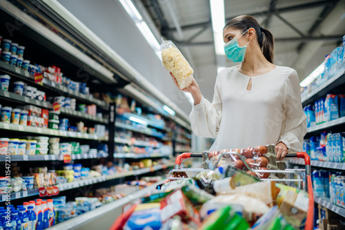 Fotografía Young person with protective face mask buying groceries/supplies in the supermarket