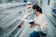 © eldarnurkovic - Woman wearing face mask buying in supermarket/drugstore with sold-out supplies.Preparation for a pandemic quarantine due to coronavirus covid-19 outbreak.Hygiene, cleaning and disinfection products.