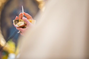 Priest' hands during a wedding ceremony/nuptial mass (shallow DOF; color toned image)