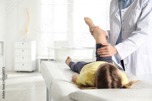 Fotomural Professional orthopedist examining little patient's leg in clinic