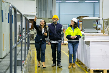 Group of factory technicians inspecting plant. Front view of three people walking at printing house. Print manufacturing concept