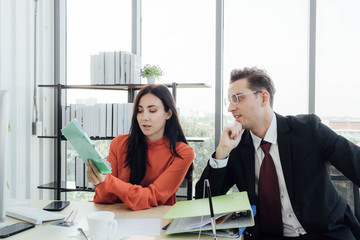 Two business people discussing about work in an office.