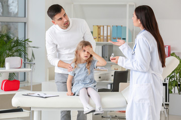 Canvas Print - Man with little daughter visiting pediatrician in clinic