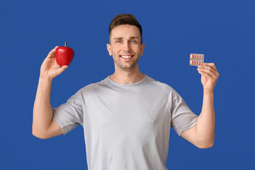 Sticker - Young man with weight loss pills and pepper on color background