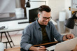 © JustLife - Designer in office. Businessman working on new architect project.