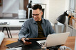 © JustLife - Designer in office. Businessman working on new architect project.