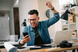 © JustLife - Handsome businessman celebrating won. Portrait of businessman in office.