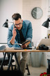 © JustLife - Businessman in office. Handsome man talking on phone at work.