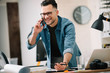 © JustLife - Businessman in office. Handsome man talking on phone at work.