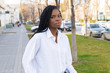 © Nana_studio - Close up portrait of a beautiful young african american woman with pigtails hairstyle in a business suit and white oversized blouse walks the street